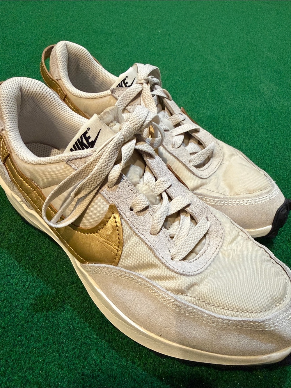 Nike Women’s off-white Sneakers with Gold Swoosh
